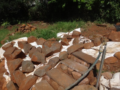 Rockery constructed out of rocks and boulders on site.  White stuff to kill grass and weeds will be cut open for planted.